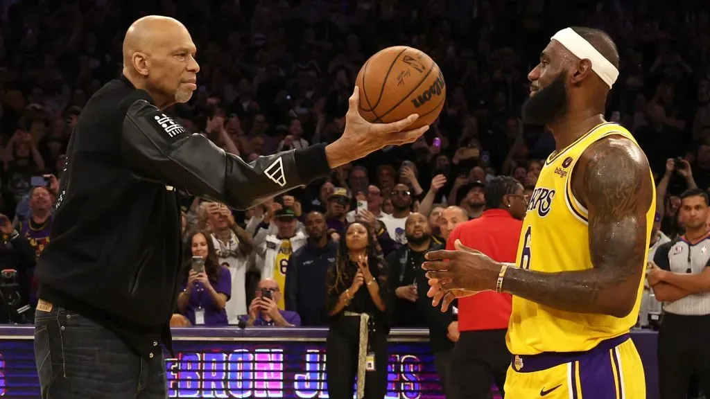 Kareem Abdul-Jabbar ceremoniously hands LeBron James #6 of the Los Angeles Lakers the ball after James passed Abdul-Jabbar to become the NBAās all-time leading scorer. (Harry How/Getty Images)