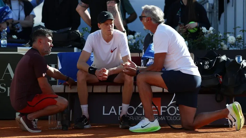 Jannik Sinner of Italy speaks with fitness coach Marco Panichi (R) and physiotherapist Ulises Badio (L) during a training session in Rome.