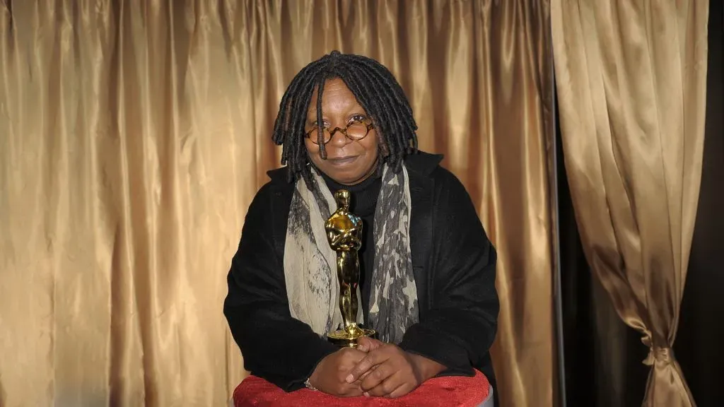 whoopi goldberg holds her Oscar