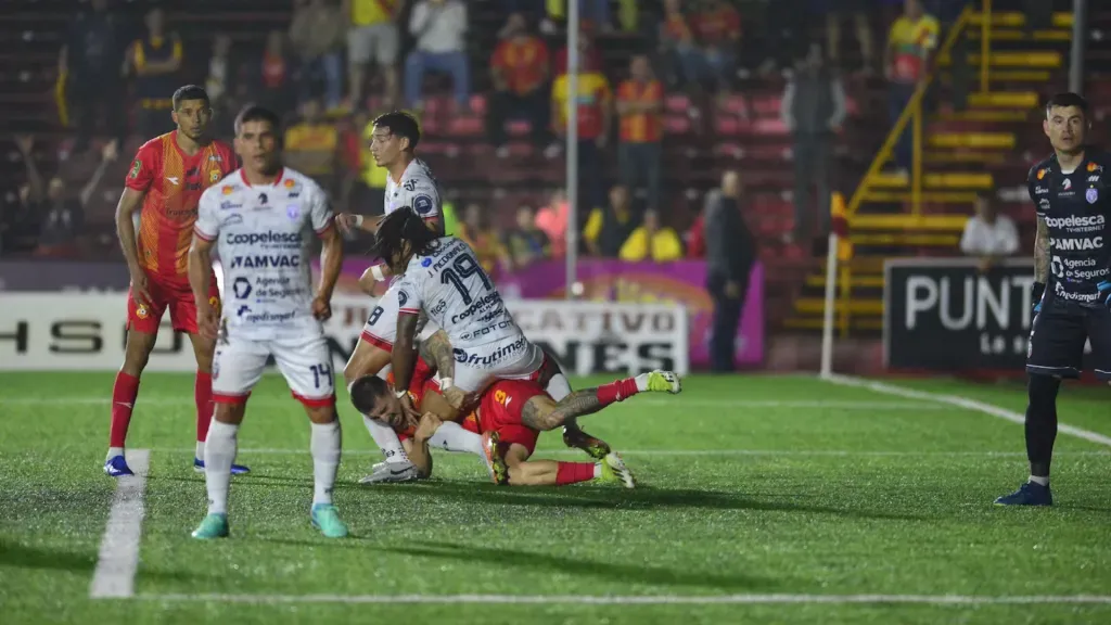 El agarrón entre McDonald y Faerron, con el que este último quiso sacar un penal a favor de Herediano. (Foto: Jorge Navarro / La Nación)