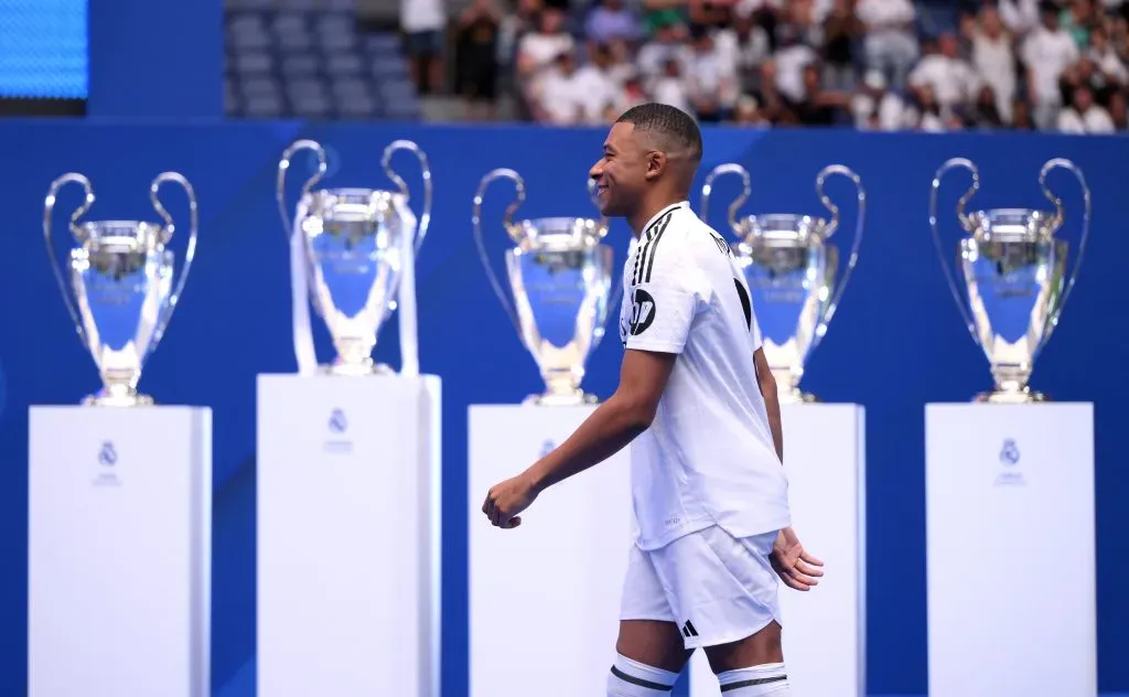 El nuevo fichaje del Real Madrid, Kylian Mbappe camina junto a los trofeos de la UEFA Champions League mientras es presentado en el Estadio Santiago Bernabéu el 16 de julio de 2024 en Madrid, España. Imagen: Getty Images.