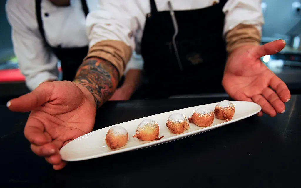 Un cocinero presenta una dulce ‘tapa’ de buñuelos de chocolate en el nuevo restaurante ‘Tickets’ creado por Ferran Andria y su hermano Albert Adria el 26 de febrero de 2011 en Barcelona, ​​España. – Foto: Getty Images.