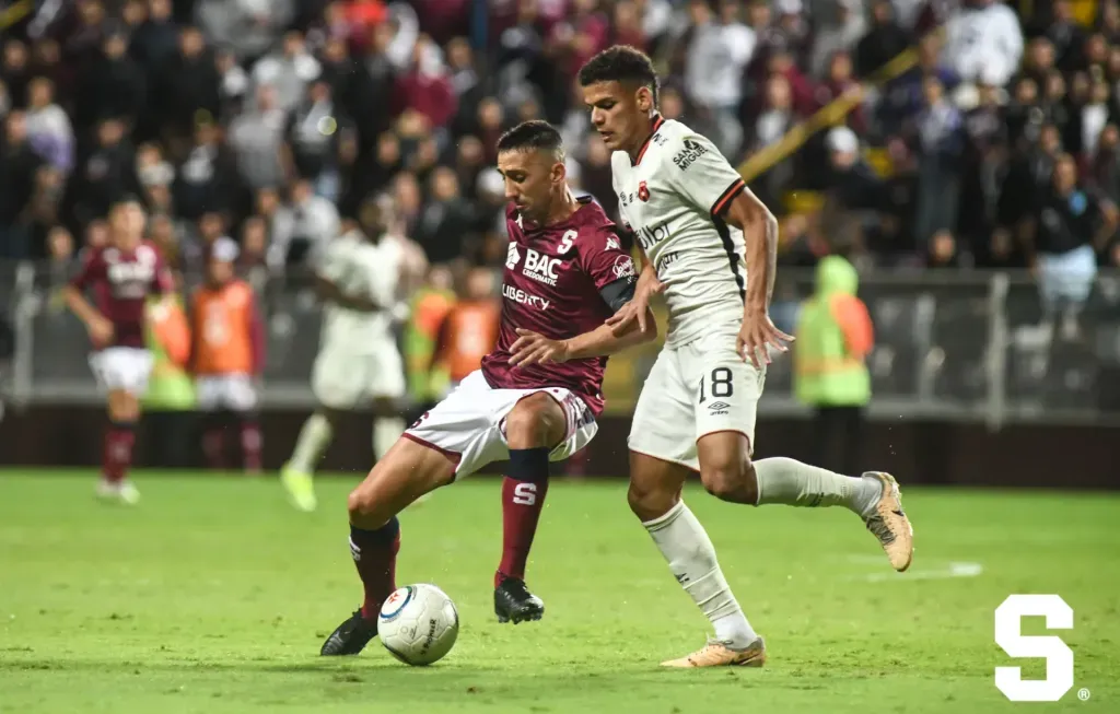 Mariano Torres protege la bola de la marca de Edward Cedeño. (Foto: Saprissa)