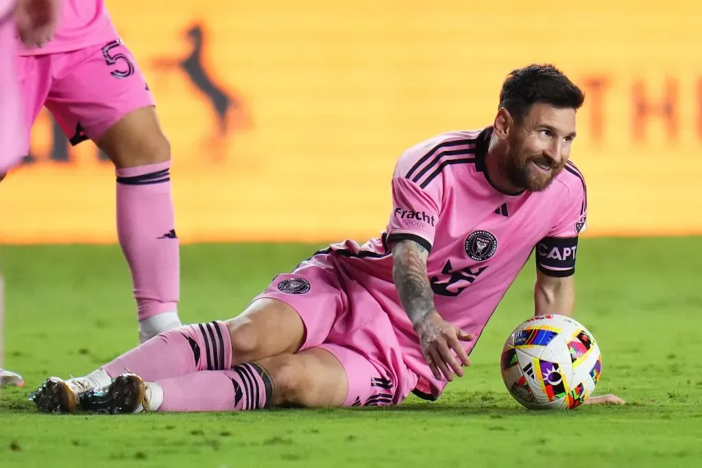 Lionel Messi caído no chão com camisa rosa do Inter Miami - Foto: Rich Storry/Getty Images