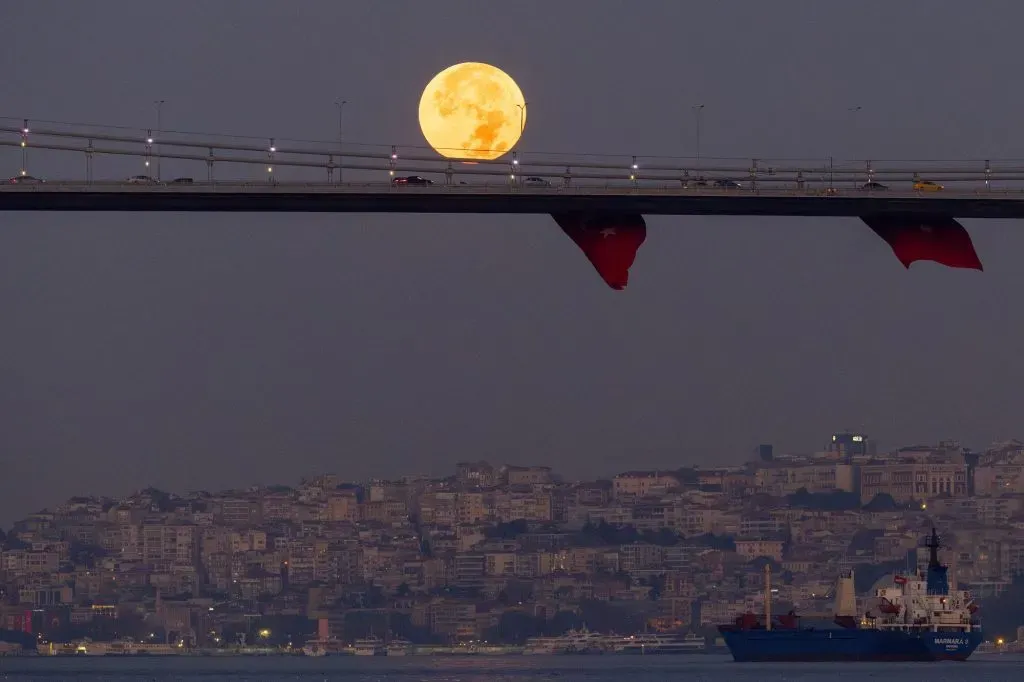 Estambul, Turquía – 31 de agosto: Autos cruzan el Puente de los Mártires mientras la Super Luna Azul se pone detrás. | Foto: Getty Images