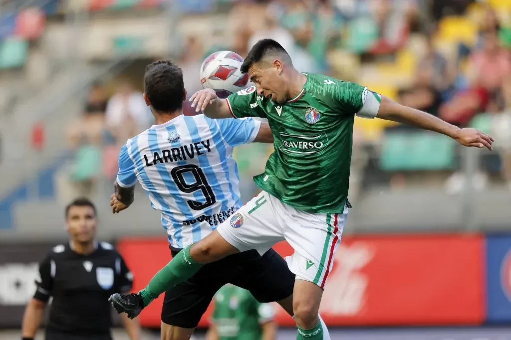 Bosso y Larrivey disputan una pelota en el medio de la cancha | Photosport