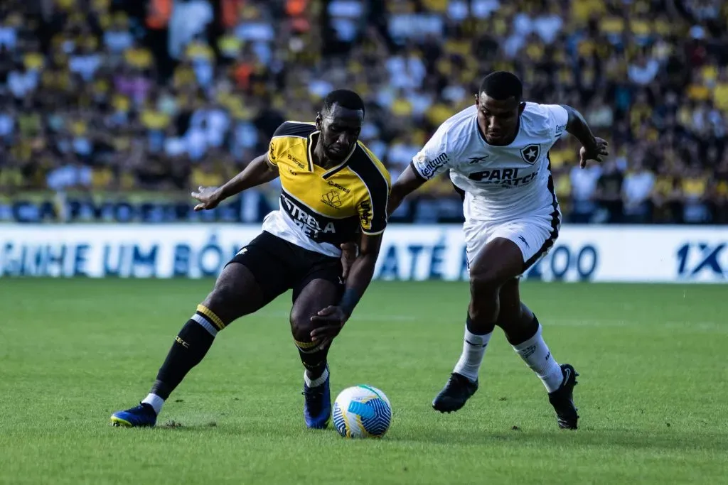 Bolasie, jogador do Criciúma, disputando bola com Cuiabano, lateral do Botafogo, em partida do primeiro turno do Brasileirão Betano. Foto: Leonardo Hubbe/AGIF