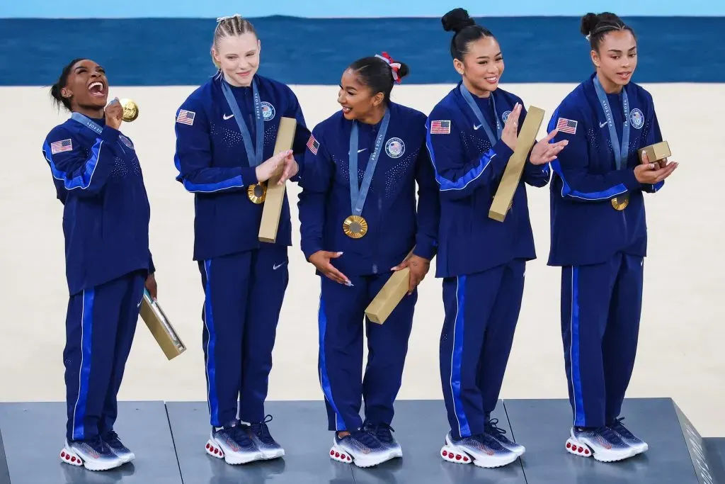 Simone Biles y el equipo USA de gimnasia femenino celebran la medalla de oro con el diploma olímpico en sus manos (Getty)