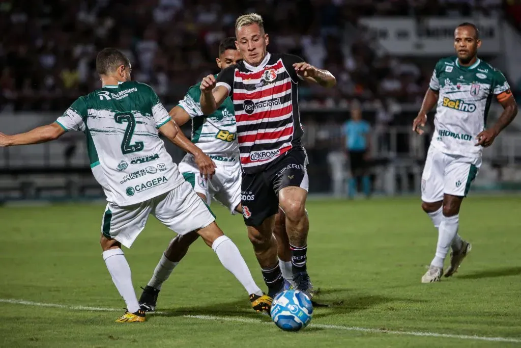 Foto: Rafael Vieira/AGIF – Emerson Galego, jogador do Santa Cruz, disputa lance com Guilherme Lucena, jogador do Sousa, durante partida no estadio Arruda pelo campeonato Brasileiro D 2023.