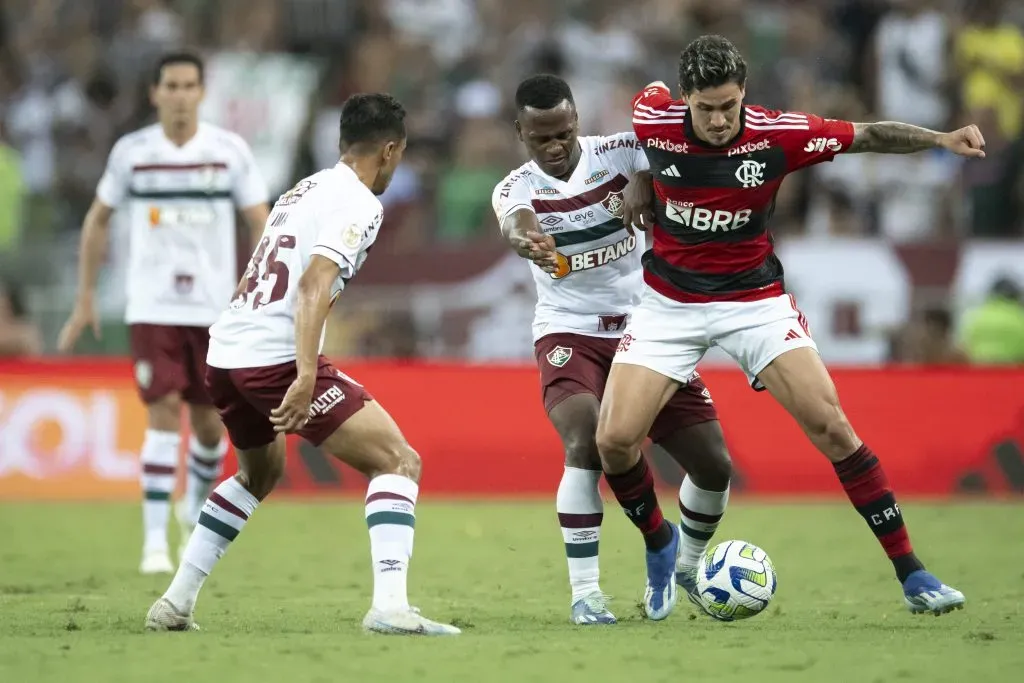 Pedro disputa a bola contra os jogadores do Fluminense em clássico no Maracanã. Foto: Jorge Rodrigues/AGIF