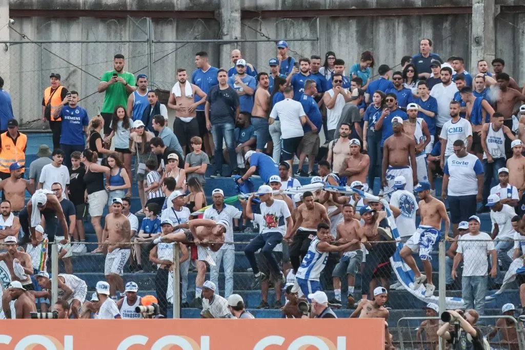 Torcida do Cruzeiro pula a grade divisória e invade gramado da Vila Capanema, durante partida contra Coritiba. Foto: Robson Mafra/AGIF