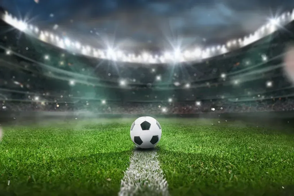 Bola de futebol sobre o gramado do estádio