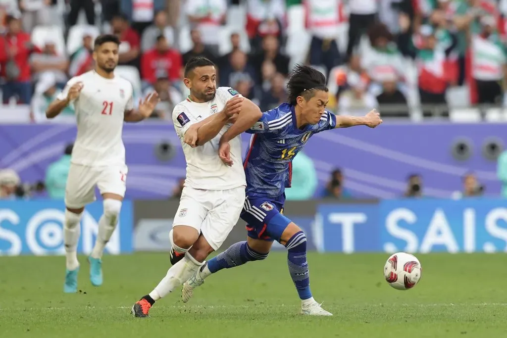 Maikuma Seiya, do Japão, disputa bola com Omid Ebrahimi Zarandini, do Irã, em partida válida pelas quartas de final da Copa da Ásia, no último sábado (3) (Foto: Lintao Zhang/Getty Images)