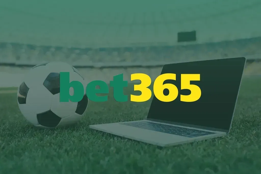 Bola de futebol e laptop sobre o gramado do estádio, com logo bet365 em verde e amarelo