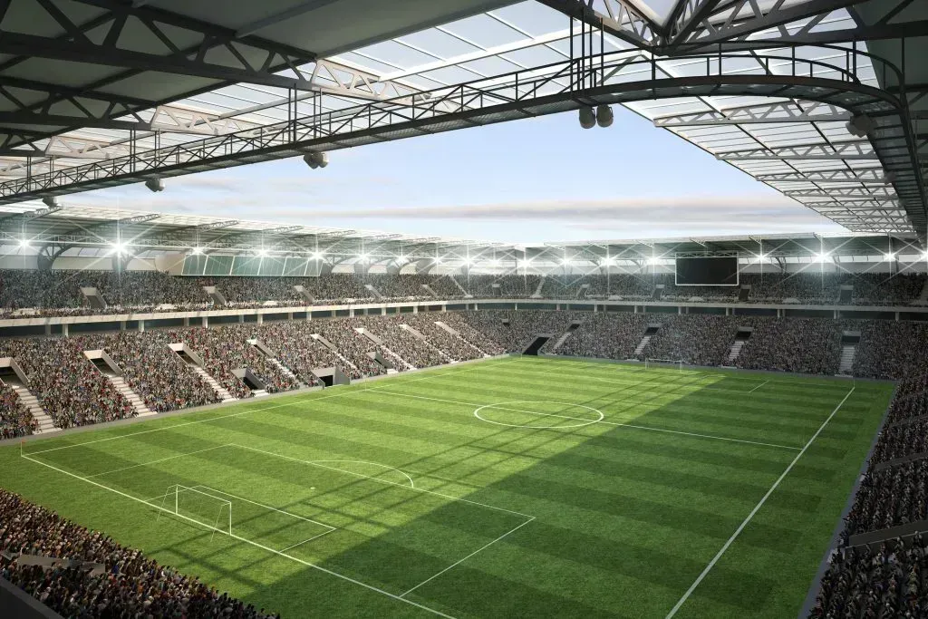 Vista interior de estádio de futebol, com campo e arquibancadas