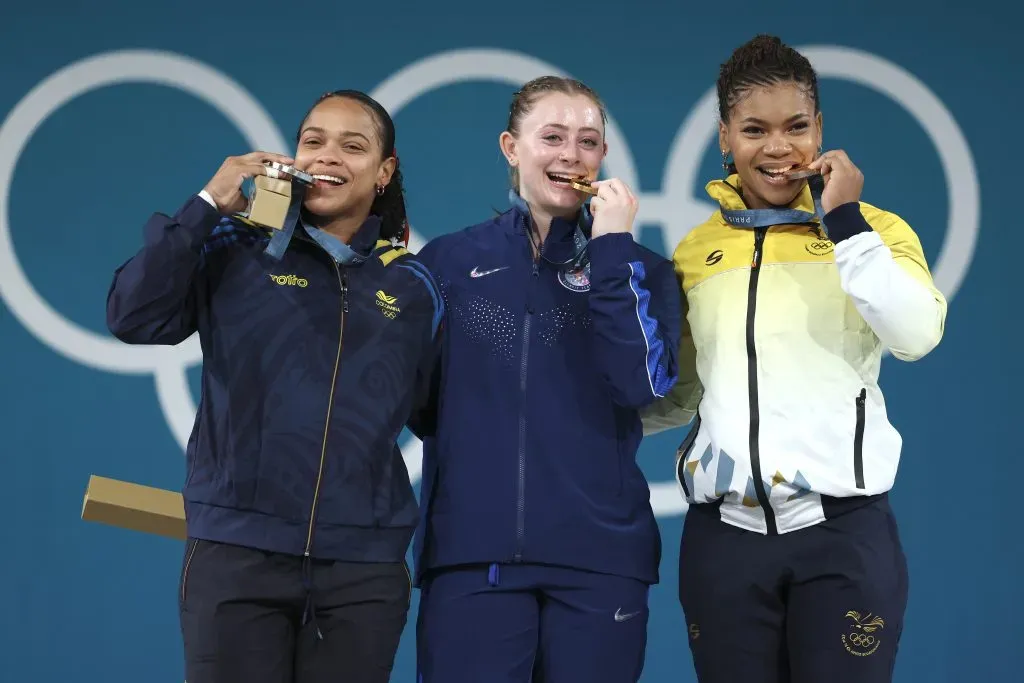 PARÍS, FRANCIA – 9 DE AGOSTO: La medallista de oro Olivia Reeves del equipo de Estados Unidos (C), la medallista de plata Mari Leivis Sánchez del equipo Colombia (I) y la medallista de bronce Angie Paola Palacios Dajomes del equipo Ecuador (D) muerden sus medallas en el podio durante La ceremonia de entrega de medallas.  (Foto de Lars Baron/Getty Images)