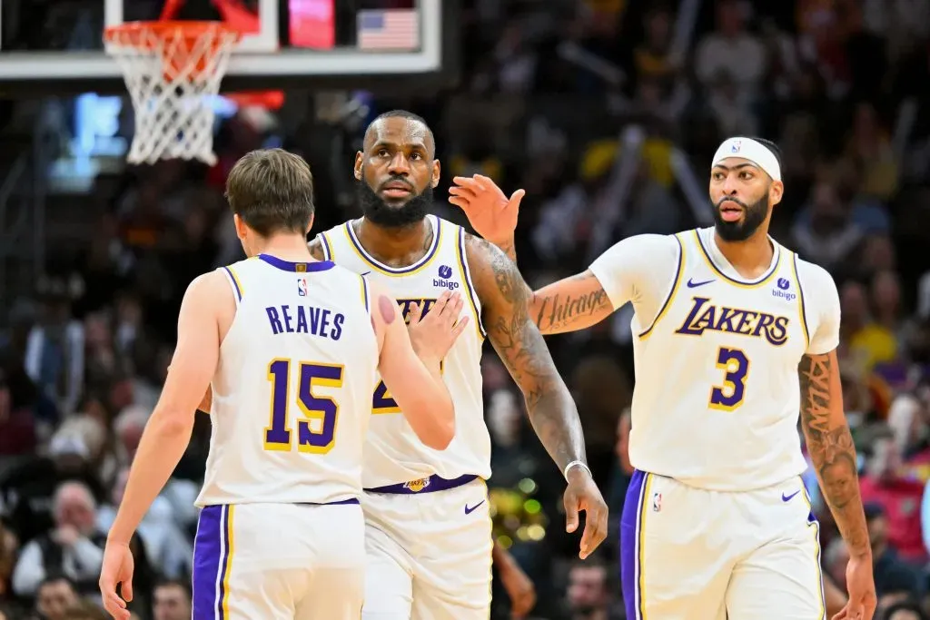 Austin Reaves #15 and Anthony Davis #3 celebrate with LeBron James #23 of the Los Angeles Lakers. Jason Miller/Getty Images