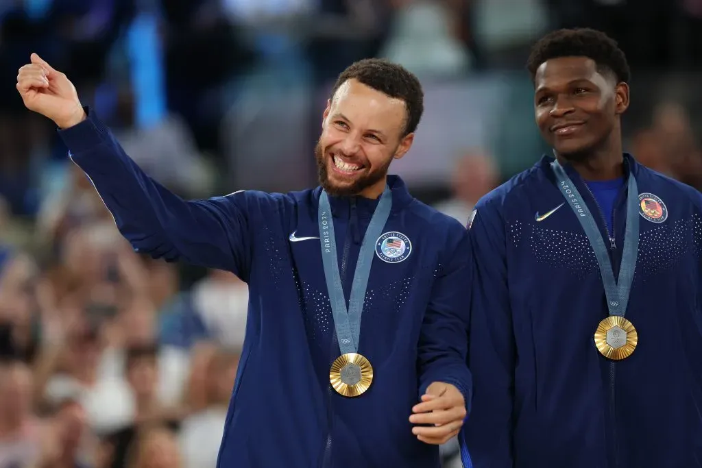 Gold medalists Stephen Curry and Anthony Edwards of Team United States smile on the podium. Gregory Shamus/Getty Images