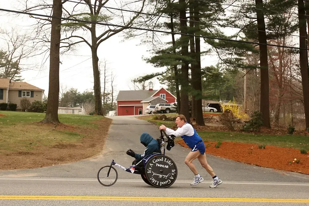 HOPKINTON, MA – APRIL 21: Dick Hoyt pushes Rick Hoyt as they compete in the 2008 Boston Marathon on April 21,2008 in Hopkinton, Massachusetts. Nearly 25,000 people participated in the race. (Photo by Elsa/Getty Images)