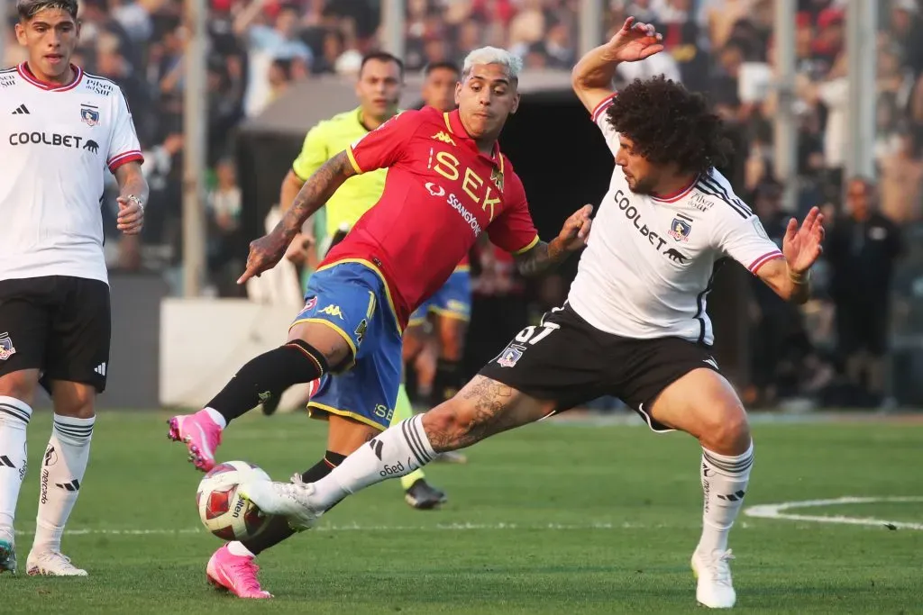 Maximiliano Falcón disputando la pelota con Rodrigo Piñeiro. (Foto: Photosport)