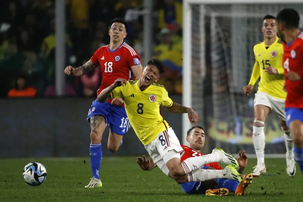 Matías Catalán foulea a Jorge Carrascal ante la mirada de Rodrigo Echeverría. Dos jugadores chilenos destacados por Arturo Vidal.  (Jonnathan Oyarzún/Photosport).