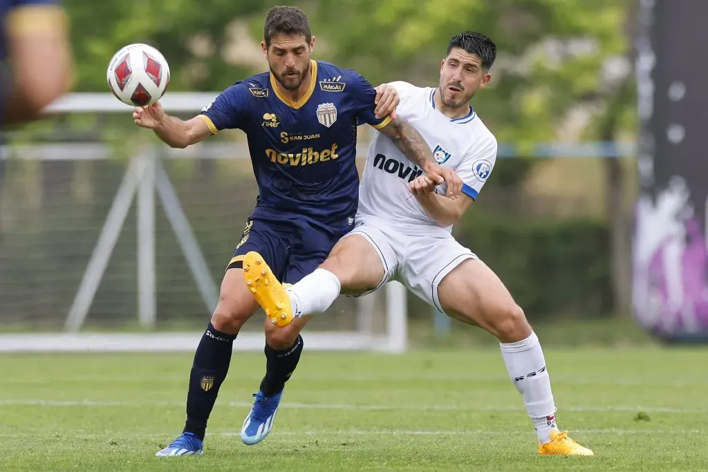 Joaquín Larrivey protege el balón ante la marca de Benjamín Gazzolo. (Pepe Alvújar/Photosport).