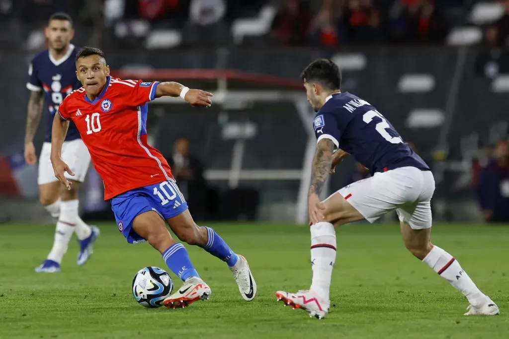 Alexis Sánchez encara a Mathias Villasanti en el duelo que Chile igualó 0-0 ante Paraguay. (Pepe Alvújar/Photosport).
