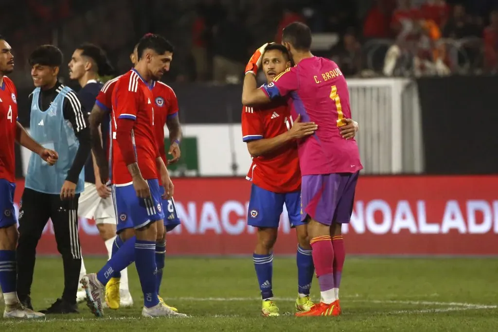 Claudio Bravo y Alexis Sánchez abrazados tras un amistoso que Chile le ganó a Paraguay en 2023. (Jonnathan Oyarzún/Photosport).