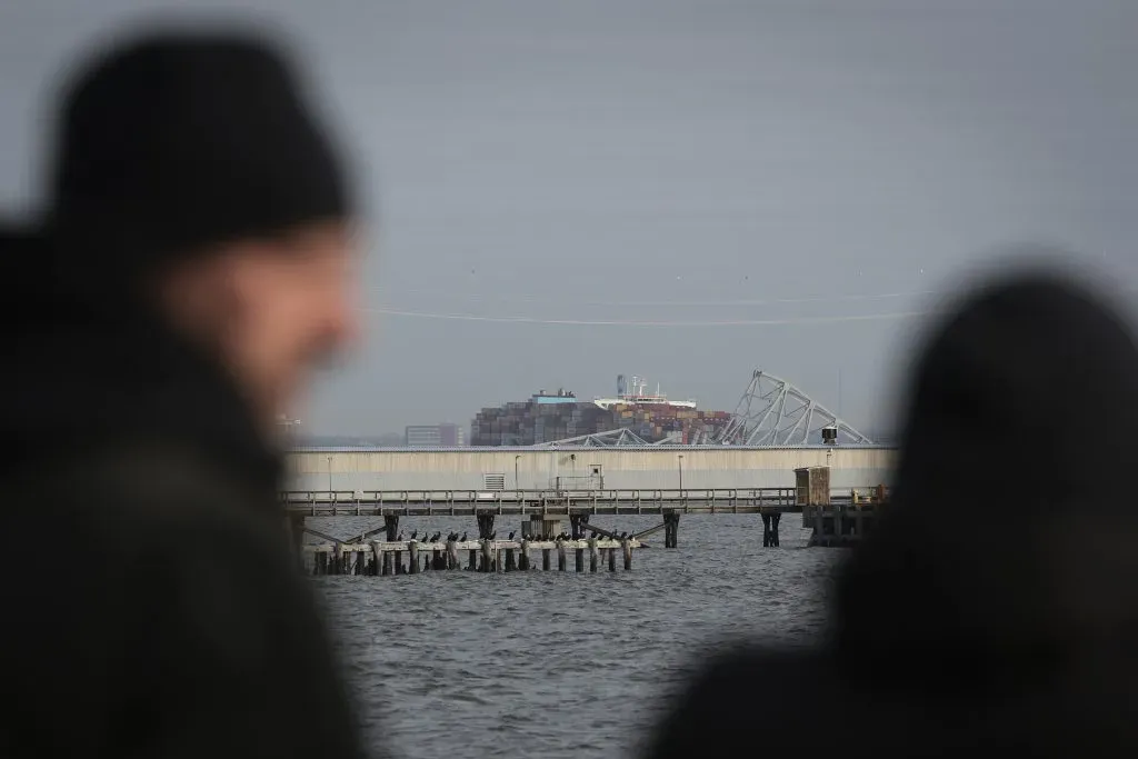 BALTIMORE, MARYLAND – MARCH 26: Local residents watch as a cargo ship is shown after running into and collapsing the Francis Scott Key Bridge on March 26, 2024 in Baltimore, Maryland. Rescuers are searching for at least seven people, authorities say, while two others have been pulled from the Patapsco River.  (Photo by Win McNamee/Getty Images)