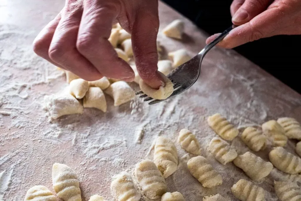Una persona marca los gnocchi con un tenedor antes de cocinarlos en agua | Foto: Imago