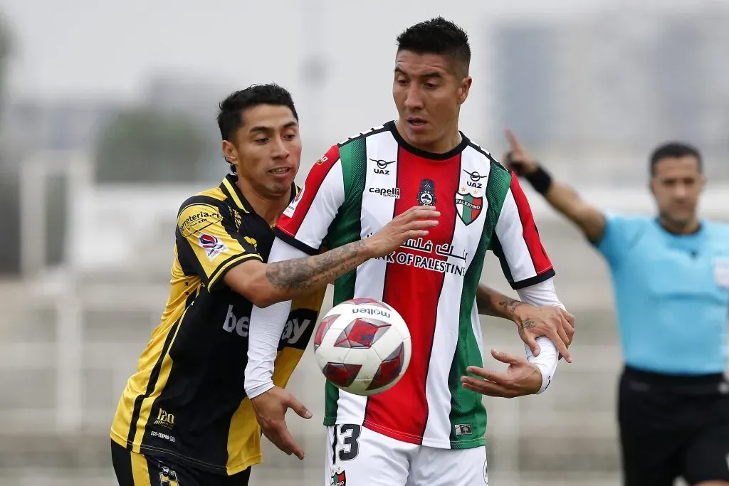 Luciano Cabral lucha con Cristian Suárez en un duelo entre Palestino y Coquimbo Unido. (Javier Salvo/Photosport).