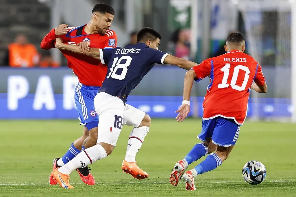 Diego Gómez lucha con Paulo Díaz, quien no será titular en el amistoso y con Alexis Sánchez. (Pepe Alvujar/Photosport).