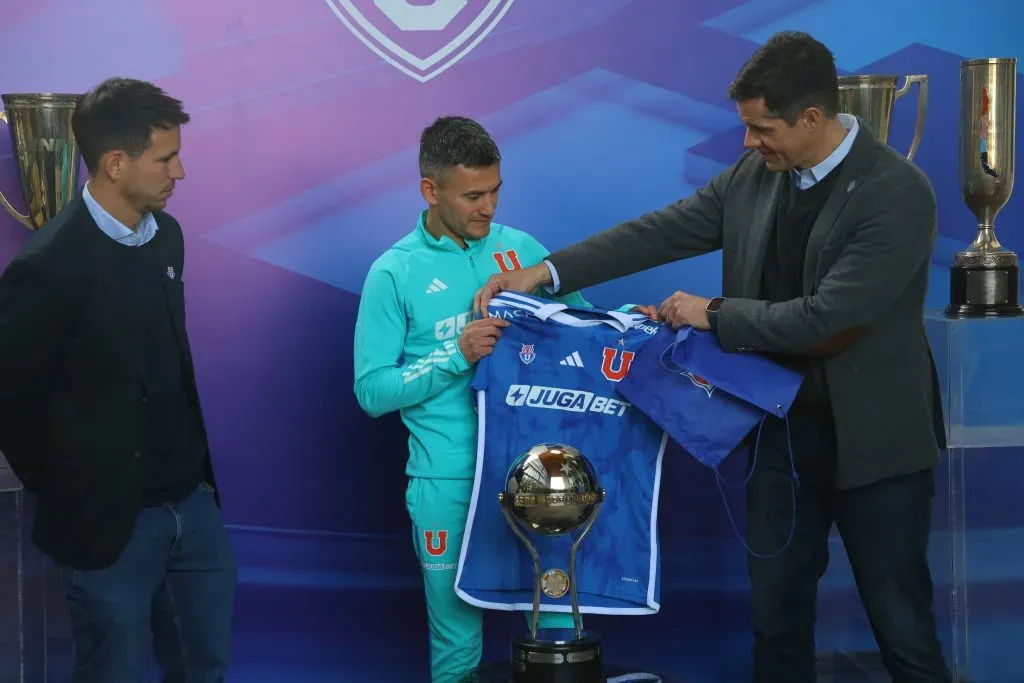 Manuel Mayo y Michael Clark, quien sostiene la camiseta, estuvieron en la presentación de Charles Aránguiz. (Marcelo Hernandez/Photosport).