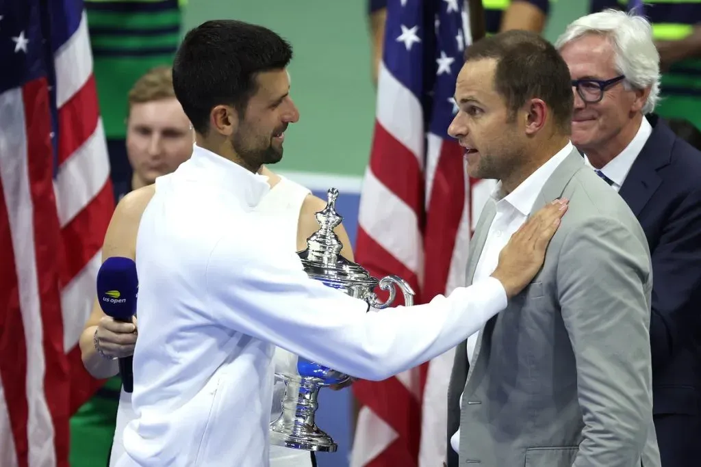 Novak Djokovic recibe el trofeo de campeón de manos del ex tenista estadounidense Andy Roddick en el US Open 2023 (Getty Images).