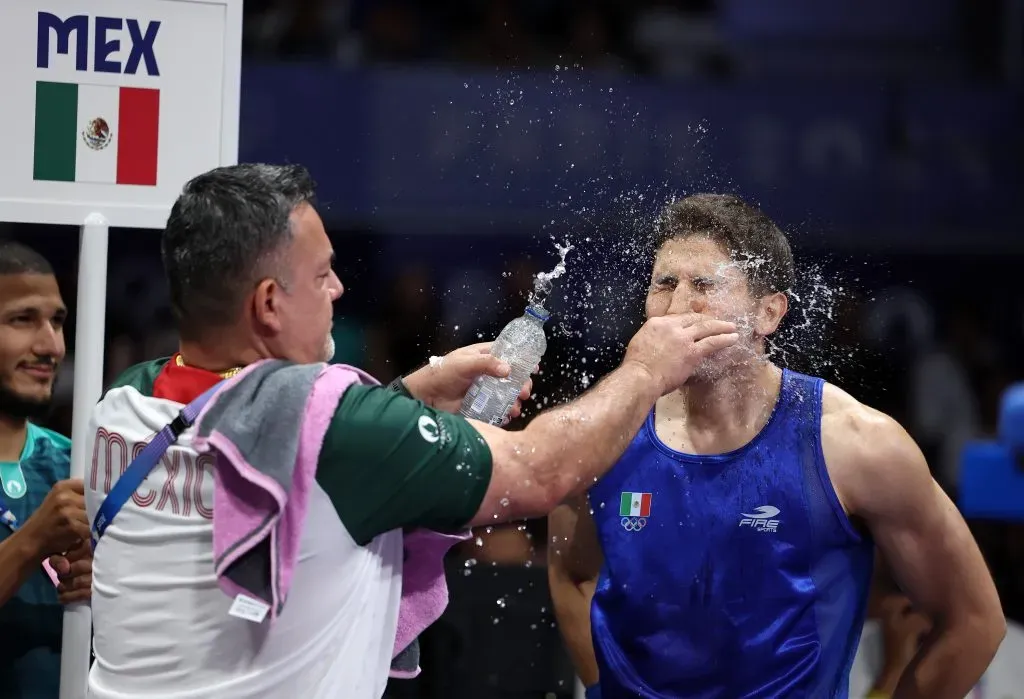 Radamés Hernández, Entrenador del Equipo de México salpica agua en la cara de Marco Verde, antes del combate de la ronda preliminar masculina de 71kg entre Tiago Muxanga del Equipo de Mozambique, en el quinto día de los Juegos Olímpicos de París 2024, en el North Paris Arena el 31 de julio de 2024 en París, Francia. Imagen: Getty Images.