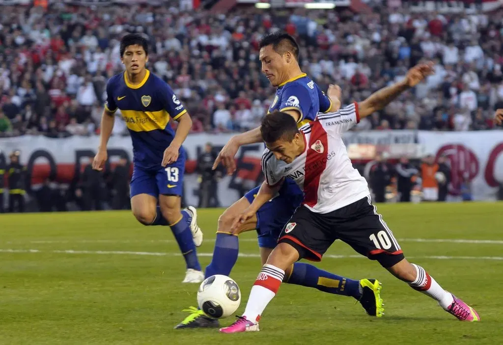 Chiqui Pérez marca a Lanzini en el Superclásico del Monumental de 2013. (Foto: IMAGO).