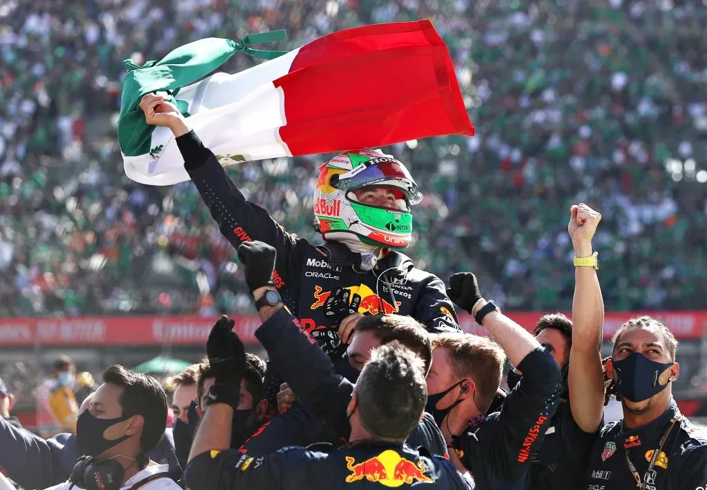 Checo Pérez levantando la bandera de México tras una carrera con Red Bull (GETTY IMAGES)