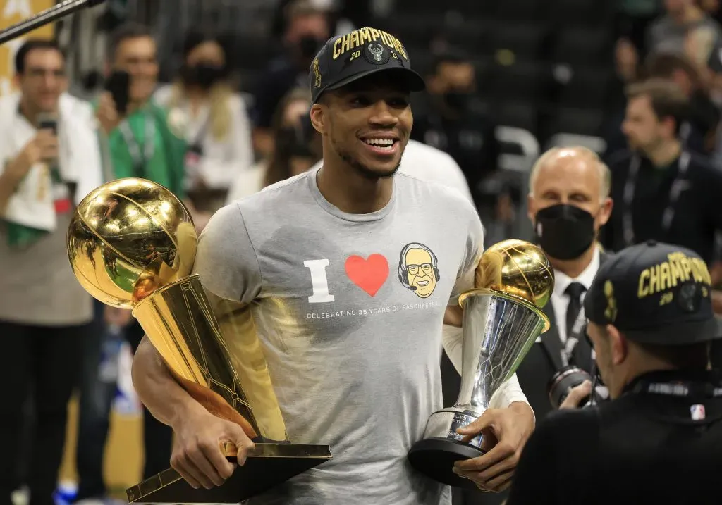 Giannis Antetokounmpo #34 of the Milwaukee Bucks holds the Bill Russell NBA Finals MVP Award and the Larry O’Brien Championship Trophy after defeating the Phoenix Suns. Justin Casterline/Getty Images