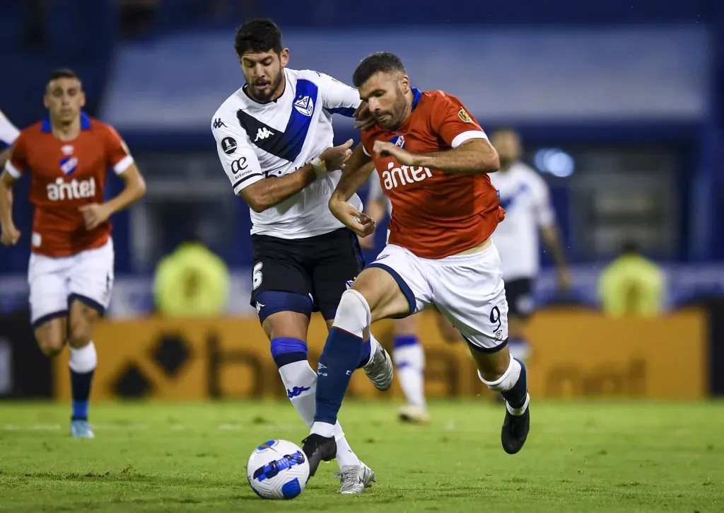 Emmanuel Gigliotti aguanta la marca del ex Colo Colo Matías de los Santos. (Marcelo Endelli/Getty Images).