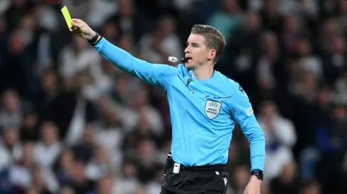 MADRID, SPAIN – APRIL 16: Referee Francois Letexier shows a yellow card to David Raya of Arsenal during the UEFA Champions League 2024/25 Quarter Final Second Leg match between Real Madrid C.F. and Arsenal FC at Estadio Santiago Bernabeu on April 16, 2025 in Madrid, Spain. (Photo by David Ramos/Getty Images)