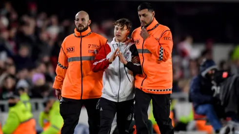 Lucas Squilarro fue sacado del terreno por dos empleados de seguridad.