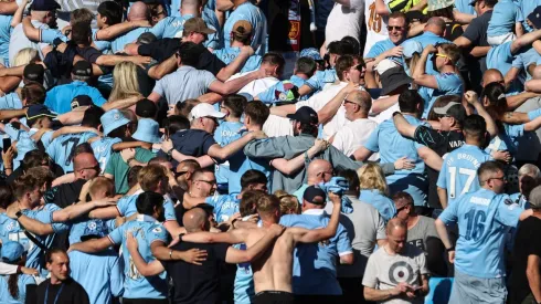 Los hinchas de Manchester City festejan de espaldas.