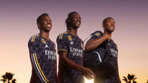 Jogadores do Real Madrid, Vini Jr, Camavinga e Alaba posam com o novo uniforme 2.<br />
Foto: Reprodução Site oficial Real Madrid