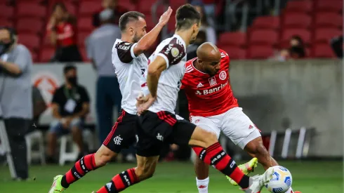 Patrick, jogador do Internacional, disputa lance com Everton Ribeiro e Rodrigo Caio, jogadores do Flamengo, durante partida no estádio Beira-Rio pelo Campeonato Brasileiro - Foto: Pedro H. Tesch/AGIF