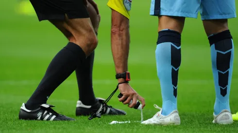 NEWCASTLE UPON TYNE, ENGLAND - AUGUST 17: Referee Martin Atkinson sprays his magic free kick line spray during the Barclays Premier League match between Newcastle United and Manchester City at St James' Park on August 17, 2014 in Newcastle upon Tyne, England. (Photo by Stu Forster/Getty Images)