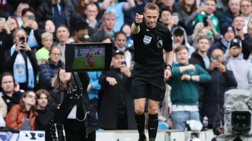 O árbitro Craig Pawson concede um pênalti ao Manchester City após verificar se há uma falta no monitor VAR do lado do campo durante a partida da Premier League entre Manchester City e Wolverhampton Wanderers no Etihad Stadium em 04 de maio de 2024 em Manchester, Inglaterra. Foto: Matt McNulty/Getty Images.