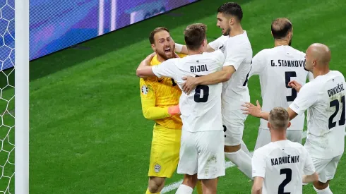 Eslovênos comemoram com Oblak após defesa em pênalti de Cristiano Ronaldo. (Photo by Alex Grimm/Getty Images)