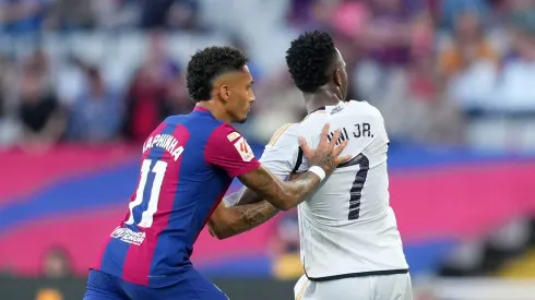 Raphinha e Vini Jr dividem a bola em partida da La Liga entre Barcelona e Real Madrid. (Photo by Alex Caparros/Getty Images)