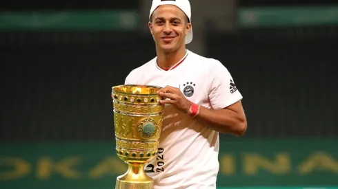 Thiago Alcantara of FC Bayern Muenchen poses with the trophy in celebration after the DFB Cup