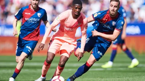 Ousmane Dembele of FC Barcelona (centre) duels for the ball with Jorge Pulido of SD Huesca (right). (Getty)